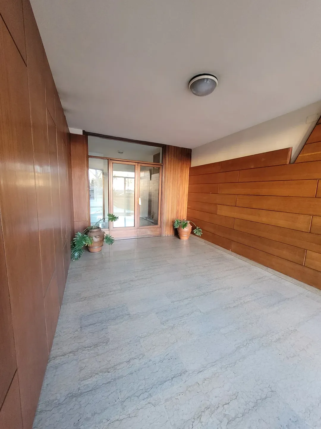 L'ingresso del palazzo, con rivestimento in legno e piante